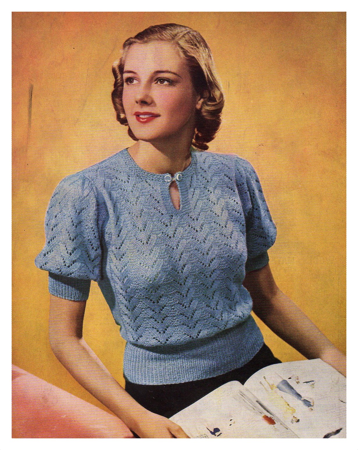 Lady wearing knitted lace work short sleeve sweater that has a leaf like motif.