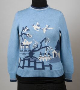 Blue sweater with willow pattern design in dark blue, black and white.