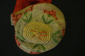 Bottom view of coloured crochet purse with flower motifs and spiral bottom.