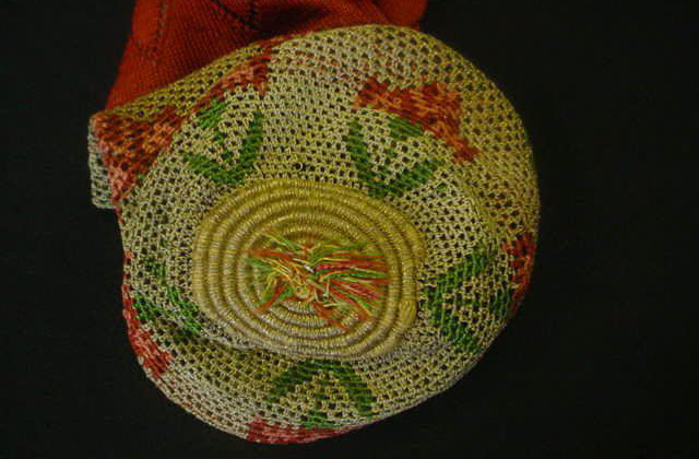 Bottom view of coloured crochet purse with flower motifs and spiral bottom.