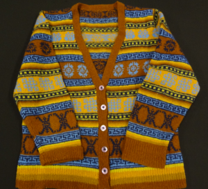 Fair Isle knitted cardigan with warm coloured stripes and motifs in brown, yellow and orange with motifs in blues and black.