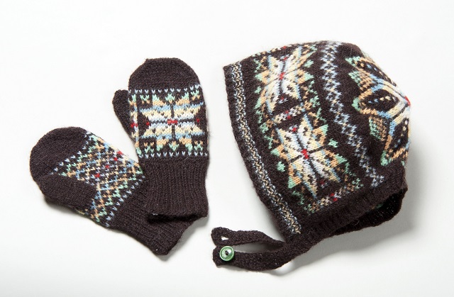Fair Isle style hat and mittens with bright star motifs on a dark brown ground