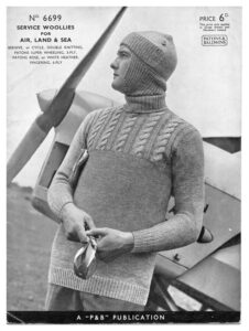 Cover of Patons & Baldwin pattern 6699 showing man leaning against aeroplane wearing a sweater with cabled top and a balaclava.