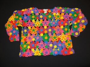 Brightly coloured crochet sweater made from a matrix of crochet flowers with circles between