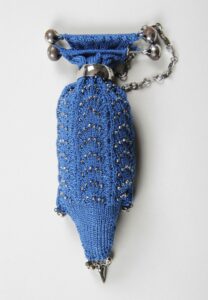 Knitted purse with beading and white metal clasp and decorations.
