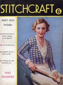 Front cover of Stitchcraft May 1933 showing lady wearing knitted low neck cardigan with blue grid pattern on white background.