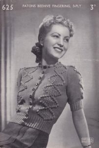 Cover of Patons leaflet 625 (3d) showing lady wearing knitted round-neck cardigan with diamond lace panels bordered with bobbles on each side of front and on short set-in sleeves.