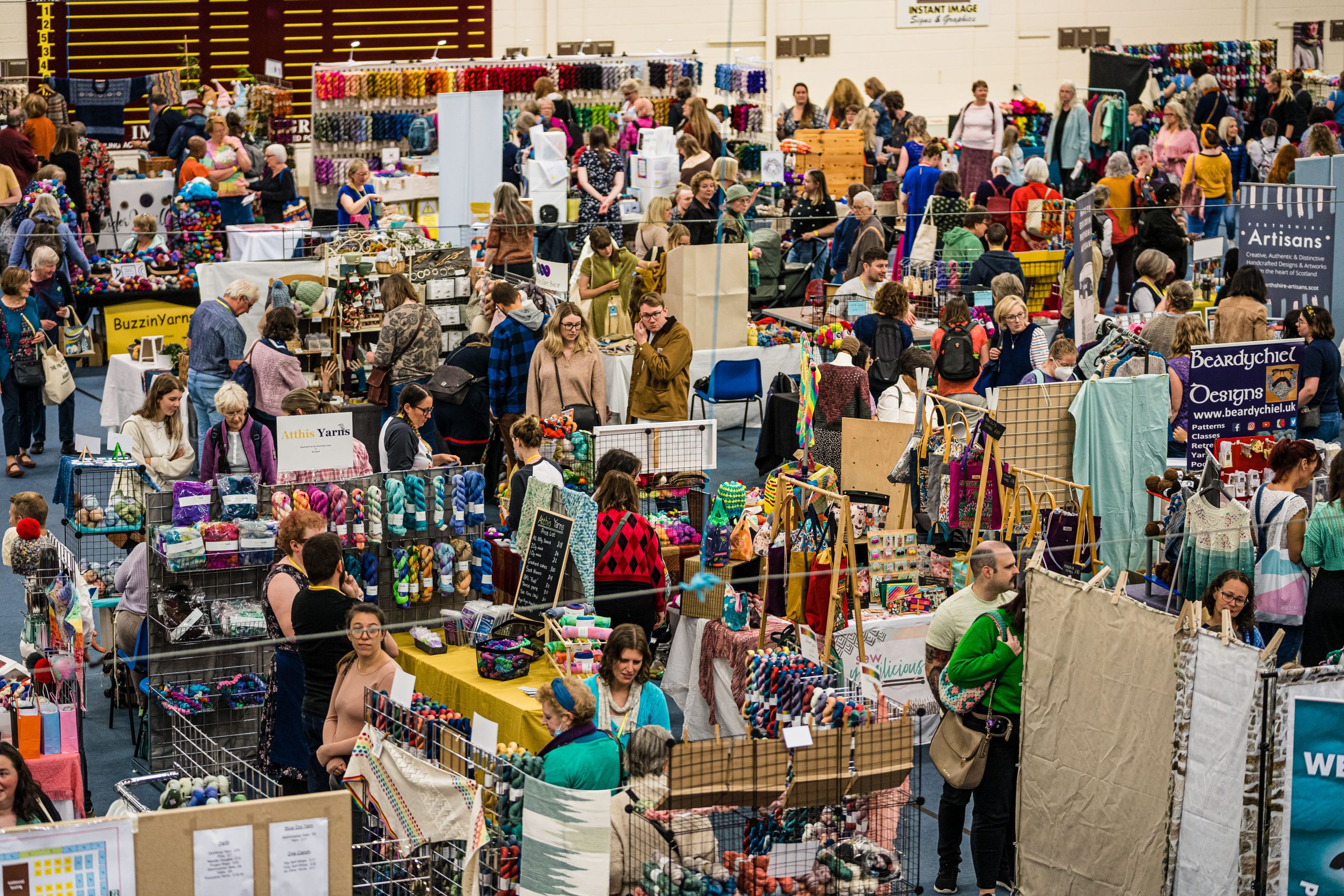 Hall filled with sellers and buyers of colourful yarn