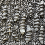 Knitted fabric with pieces of smooth flint knitted into it.
