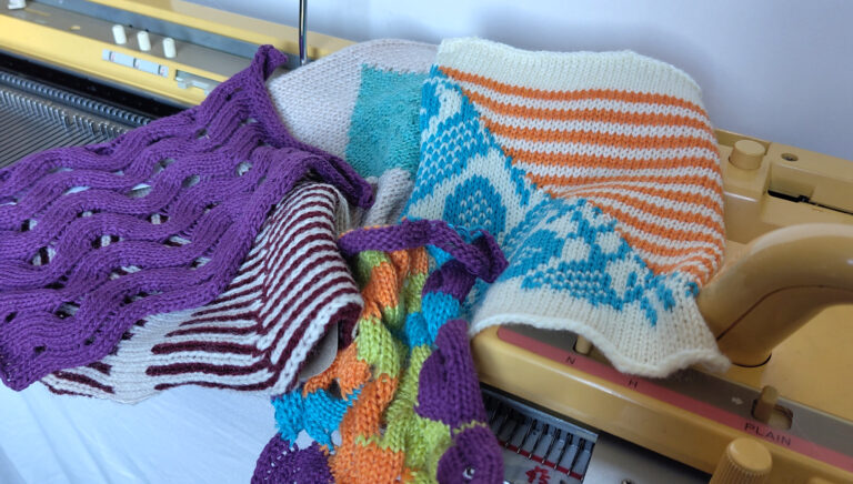 Assortment of machine knit swatches laid on a knitting machine
