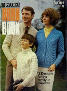 Man and woman wearing cabled cardigans with a boy wearing a cabled jumper