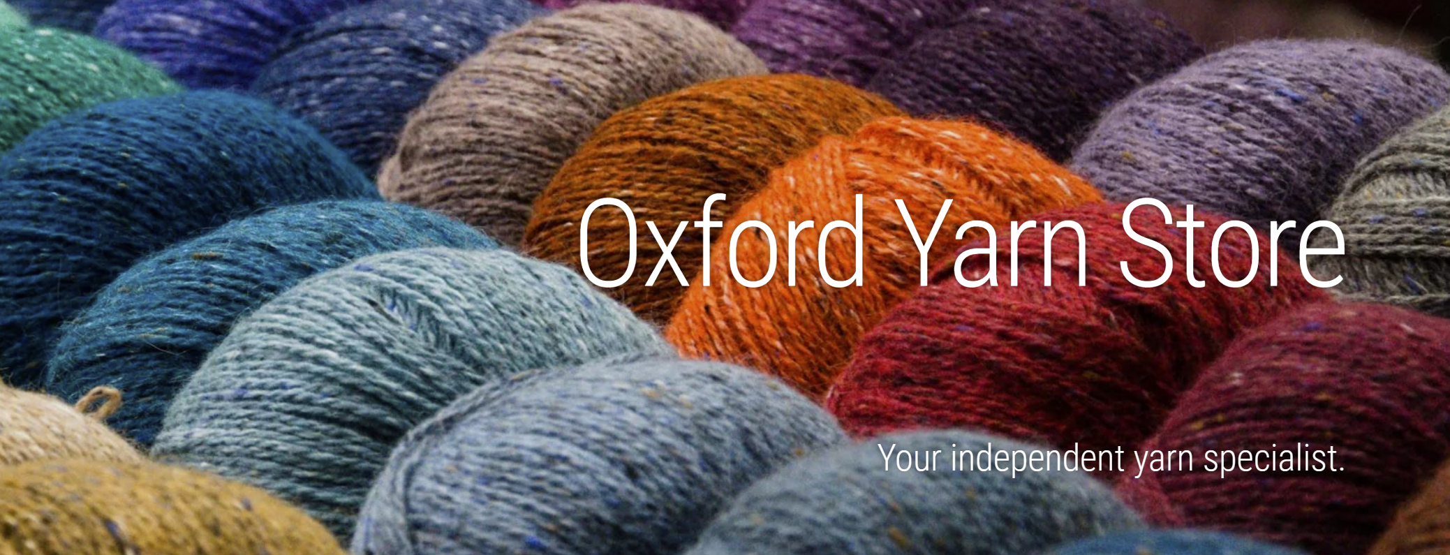 Balls of yarn behind the text "Oxford Yarn Store. Your independent yarn specialist."