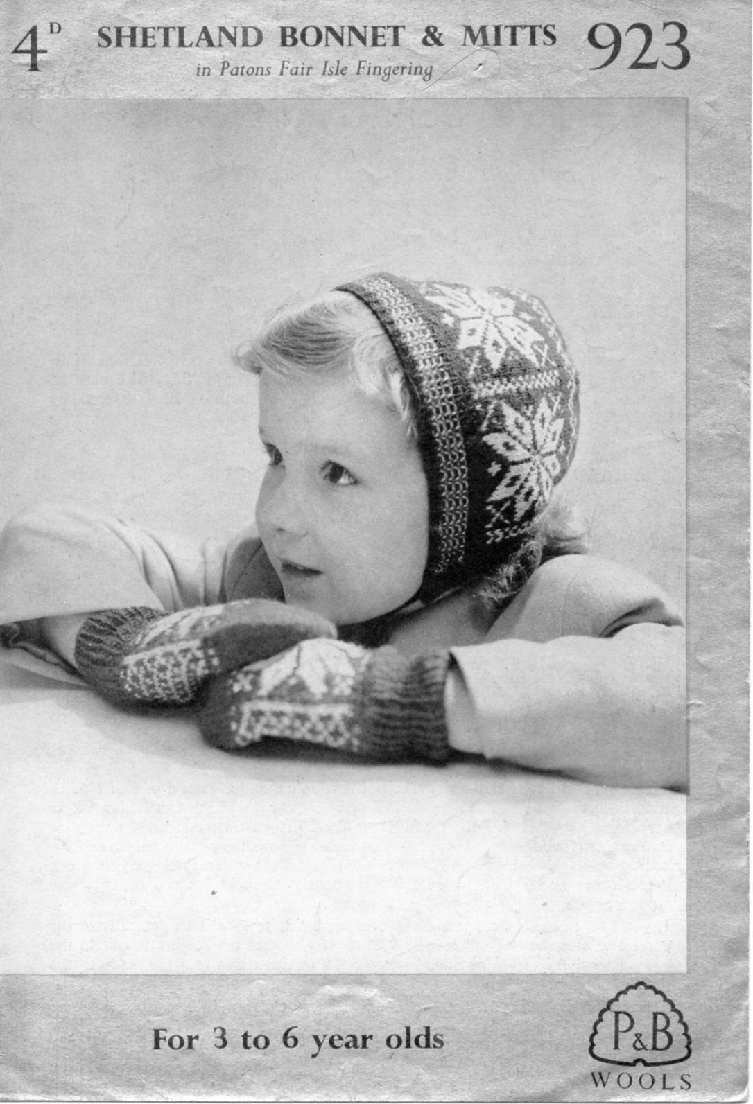 Young child wearing bonnet and mittens in Fair Isle star pattern