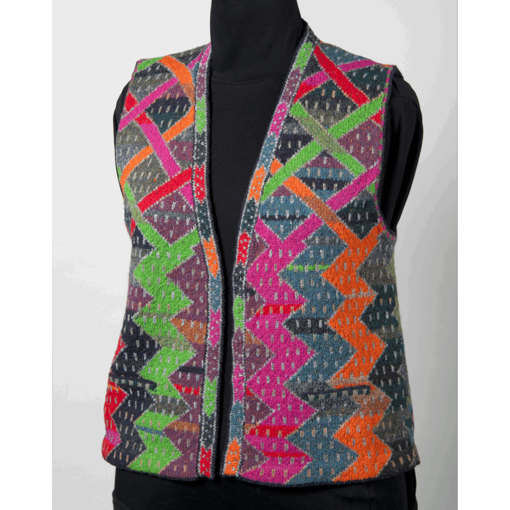 Waistcoat with no fastenings, folded hems at armholes and all edges, pockets to front. Pattern of bright zig zags at the bottom that cross for form diamonds above the bottom of the arm holes. Muted contrasting colours separate the neons, and the whole is covered by a pattern of light coloured short stripes.