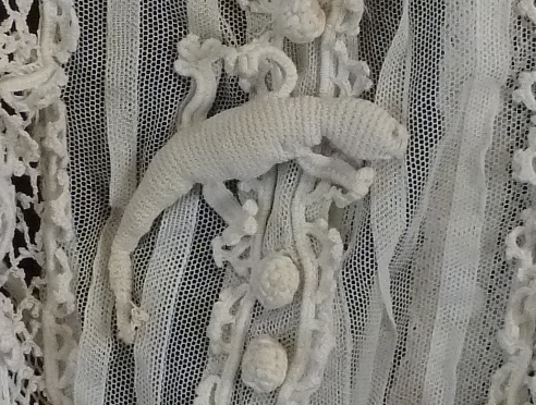 Detail from Irish crochet jacket showing a crocheted lizard.
