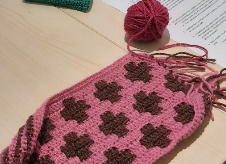 Photograph of a sample of mosaic crochet made in pink and dark red.